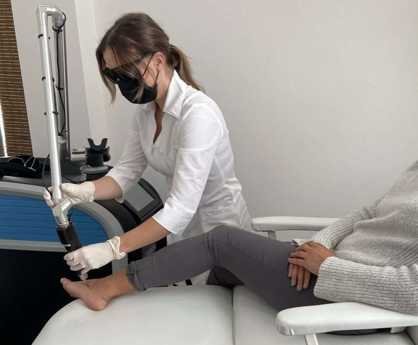 Esthetician doing a tattoo removal service in winnipeg with a picosure laser