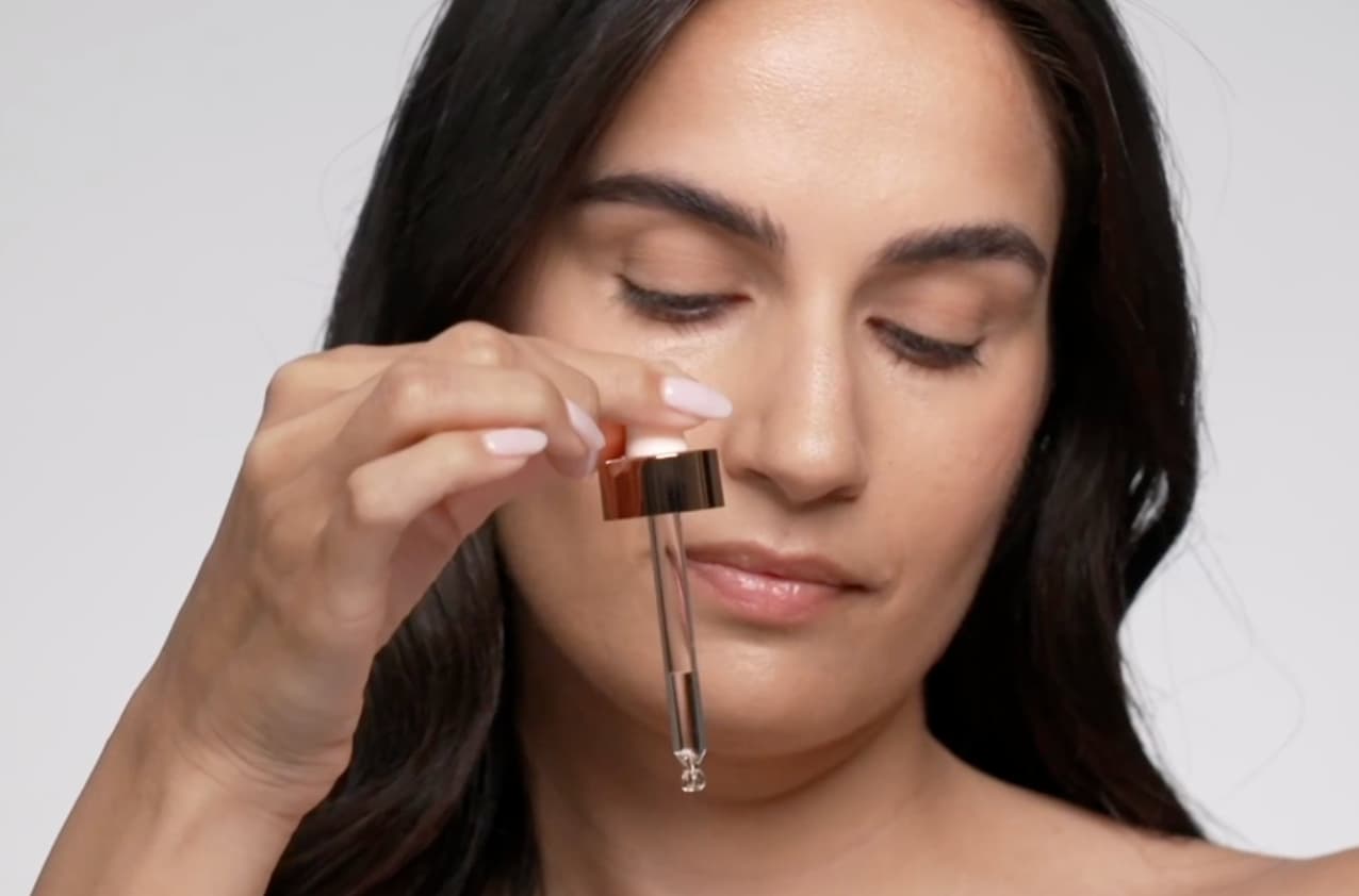 Applying Vivier Vitamin C serum with a dropper as part of a daily vitamin c skincare routine