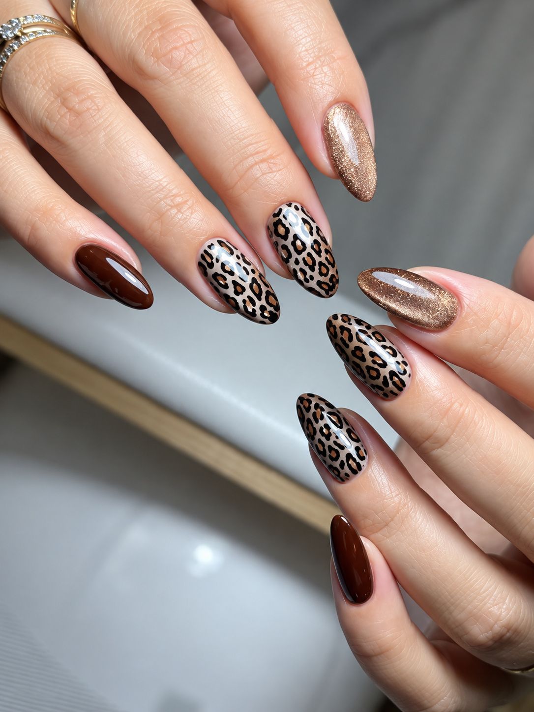 Chocolate brown, cheetah-print and champagne glitter almond nails at Total Wrapture Medi Spa