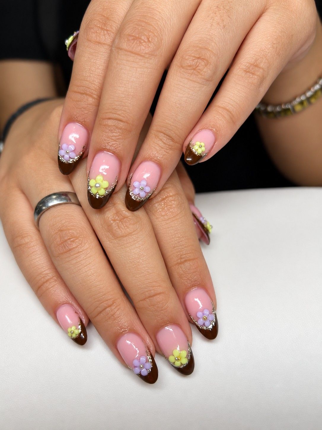 Brown French tips with pastel flower nail art at Total Wrapture Medi Spa