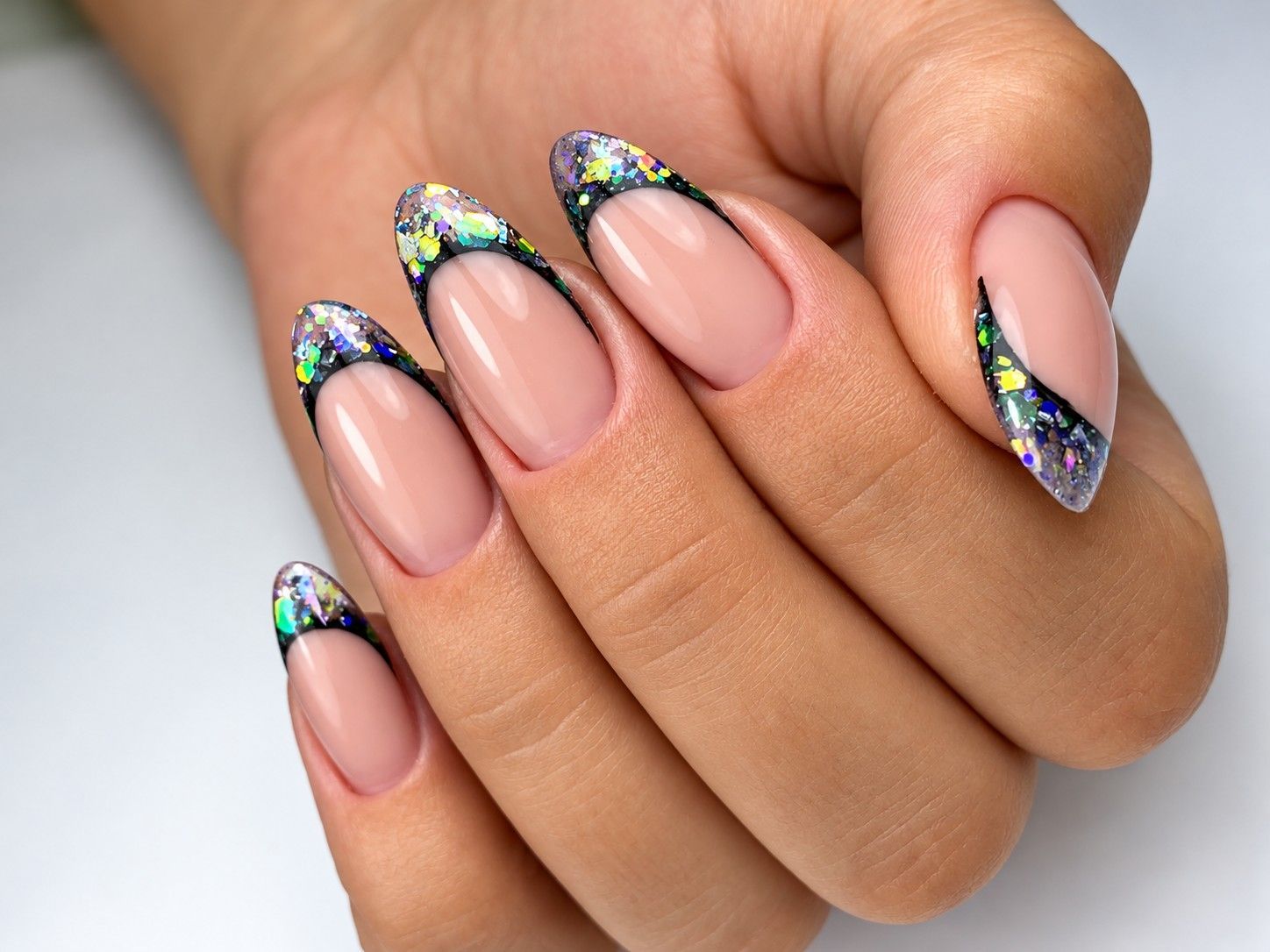 Nude almond nails with multicolour glitter French tips at Total Wrapture Medi Spa
