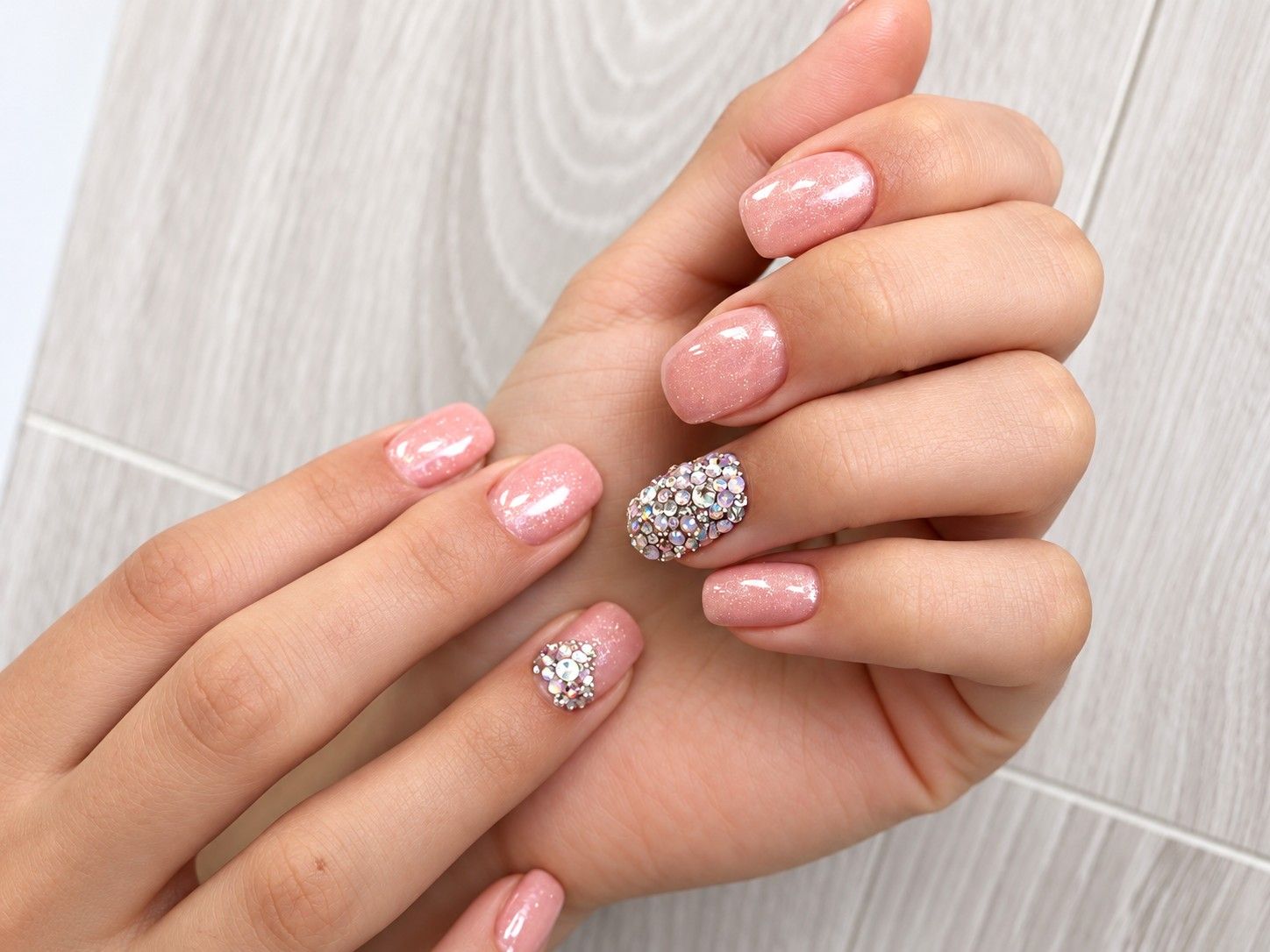 Pink shimmer manicure with rhinestone accent nails at Total Wrapture Medi Spa