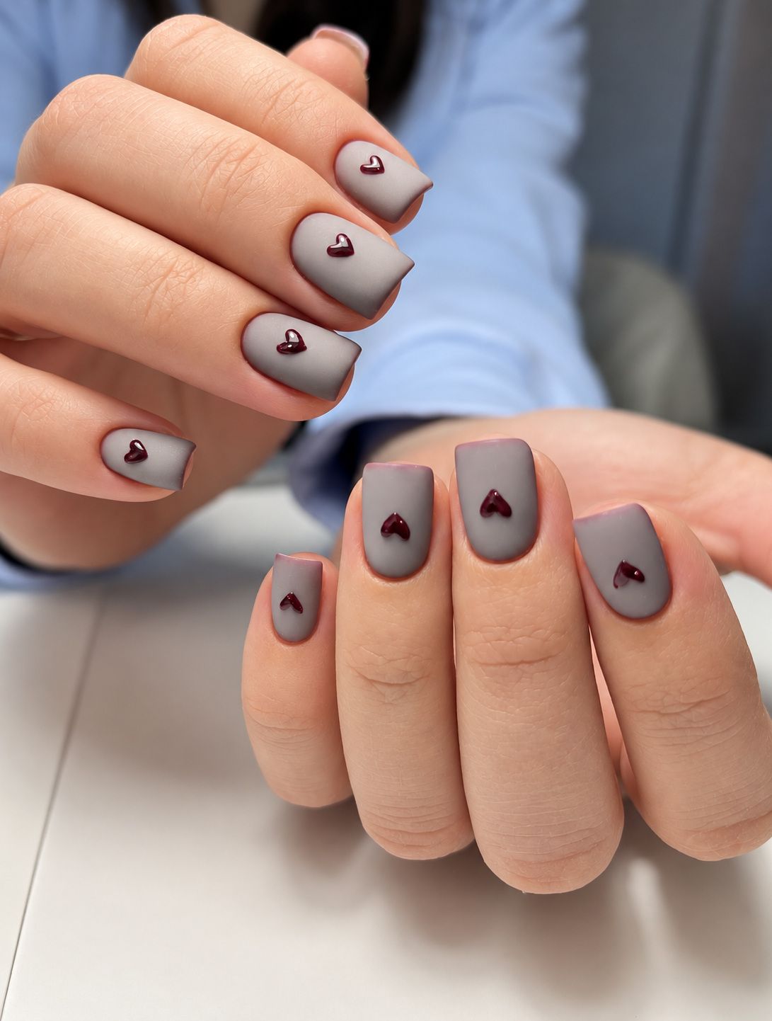 Matte grey nails with burgundy heart accents at Total Wrapture Medi Spa