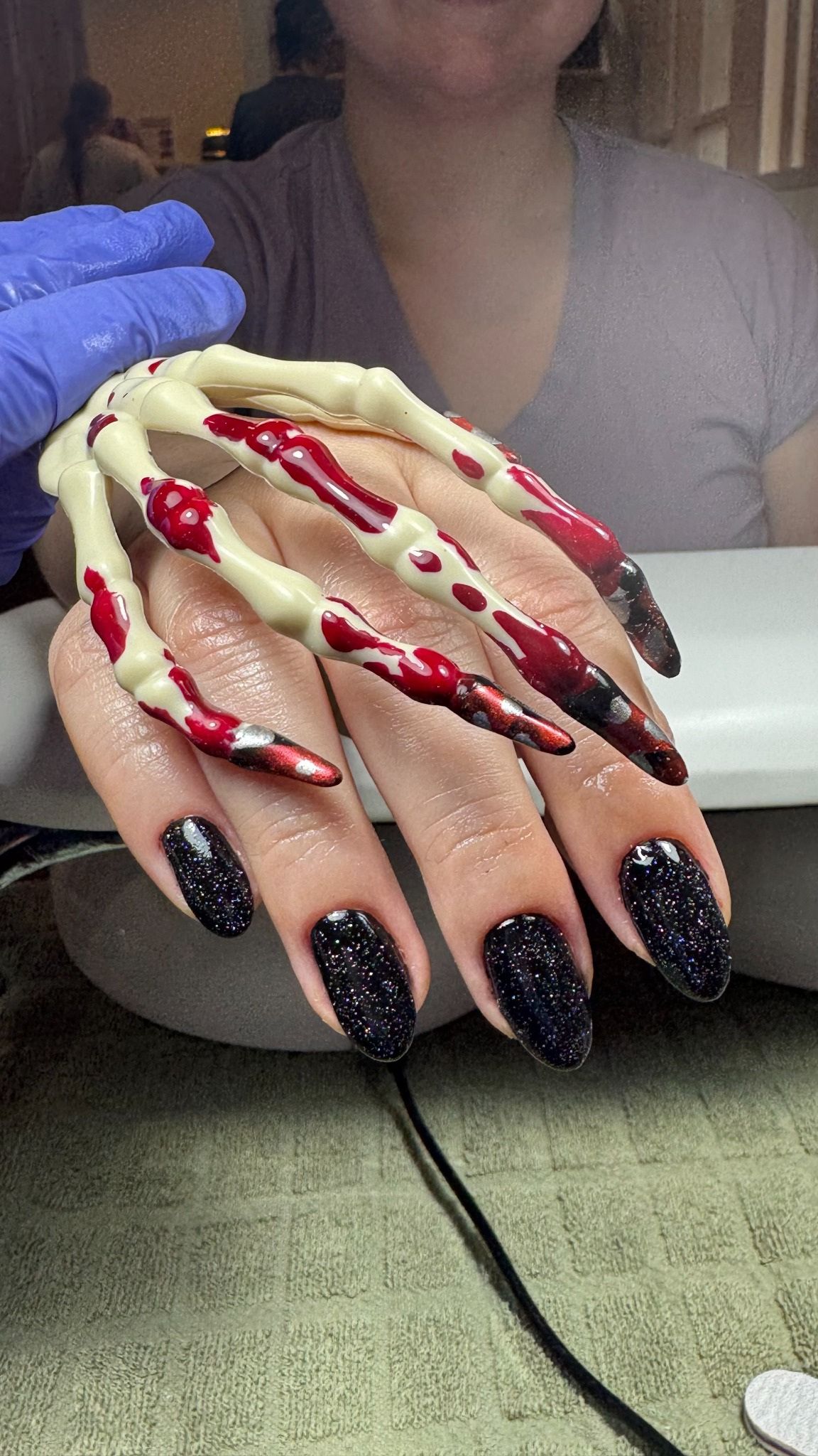 Black glitter nails with a Halloween design at Total Wrapture Medi Spa