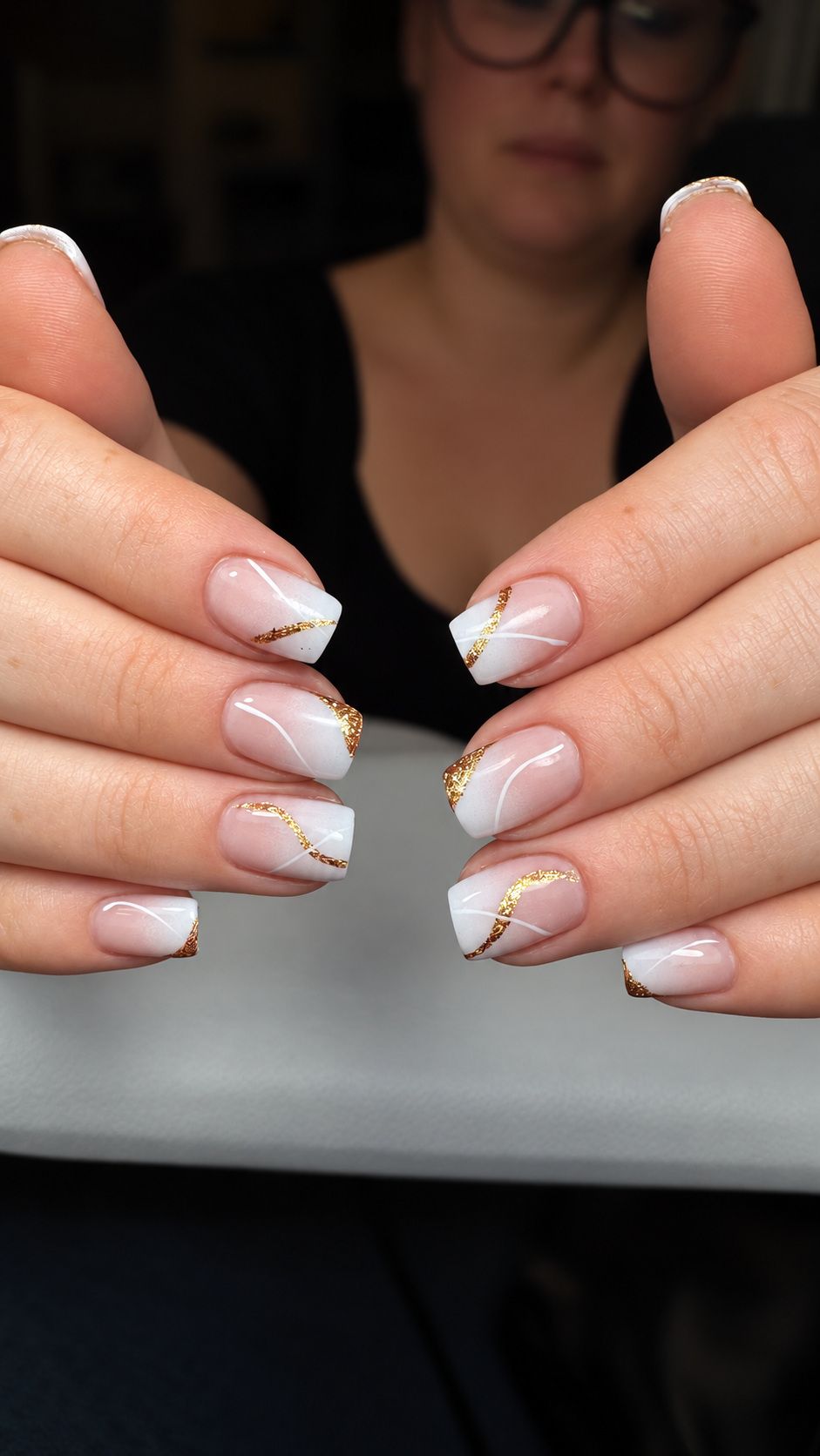 White and nude nails with gold foil and curved line art at Total Wrapture Medi Spa